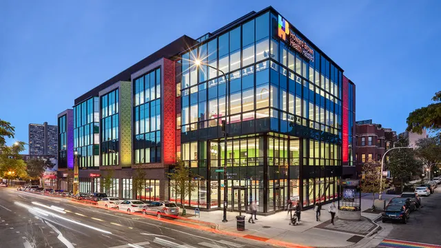 Howard Brown Health's multi-story clinic building on a Chicago street corner at dusk