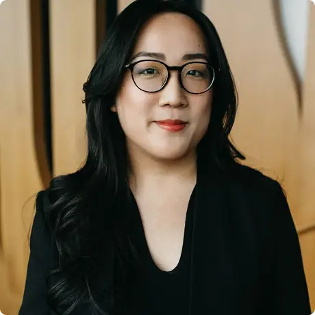 Jo Lai, VP of Customer Experience at Hopper, in a black top and glasses.